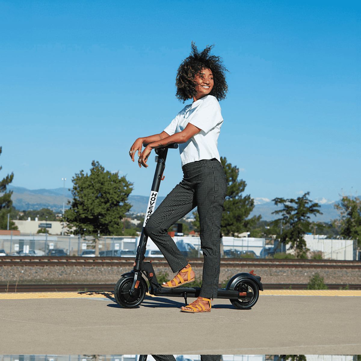 A girl takes a leisurely spin on the Hoverfly GXL MAX Electric Scooter, surrounded by breathtaking landscapes. Its compact foldable design ensures easy transport, making it the ideal travel buddy for exciting outdoor excursions.