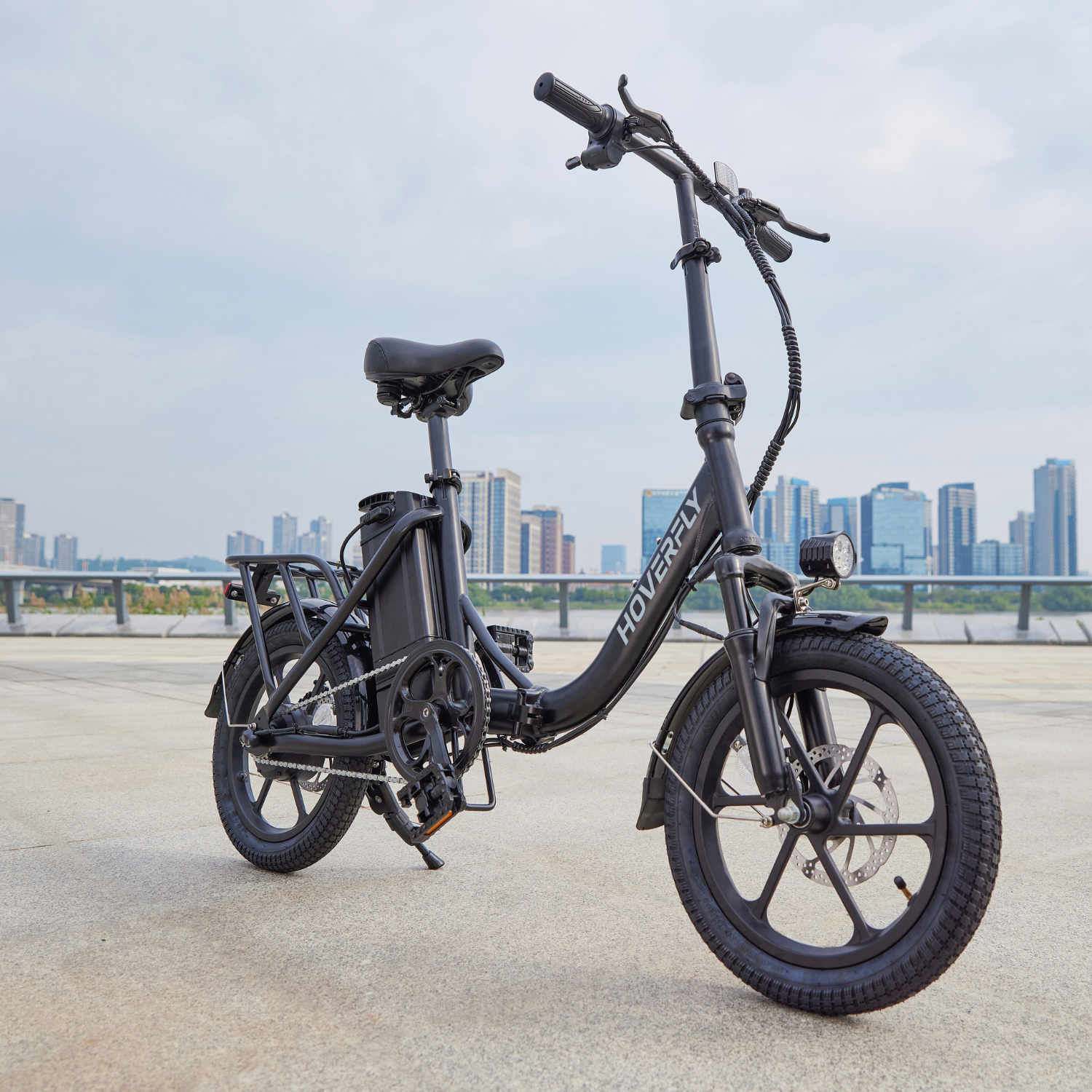 Black Hoverfly H3 Foldable E-Bike Parked Alongside Urban Roadway, Sleek & Ready for Next Adventure.